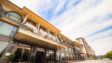 A hotel with a modern facade, large windows, and a covered entrance area.