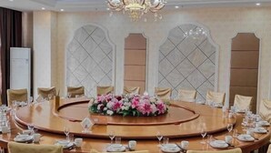 A conference room with a round table, chairs, and a chandelier. - Nuoya Business Center Hotel (Jinggangshan City)