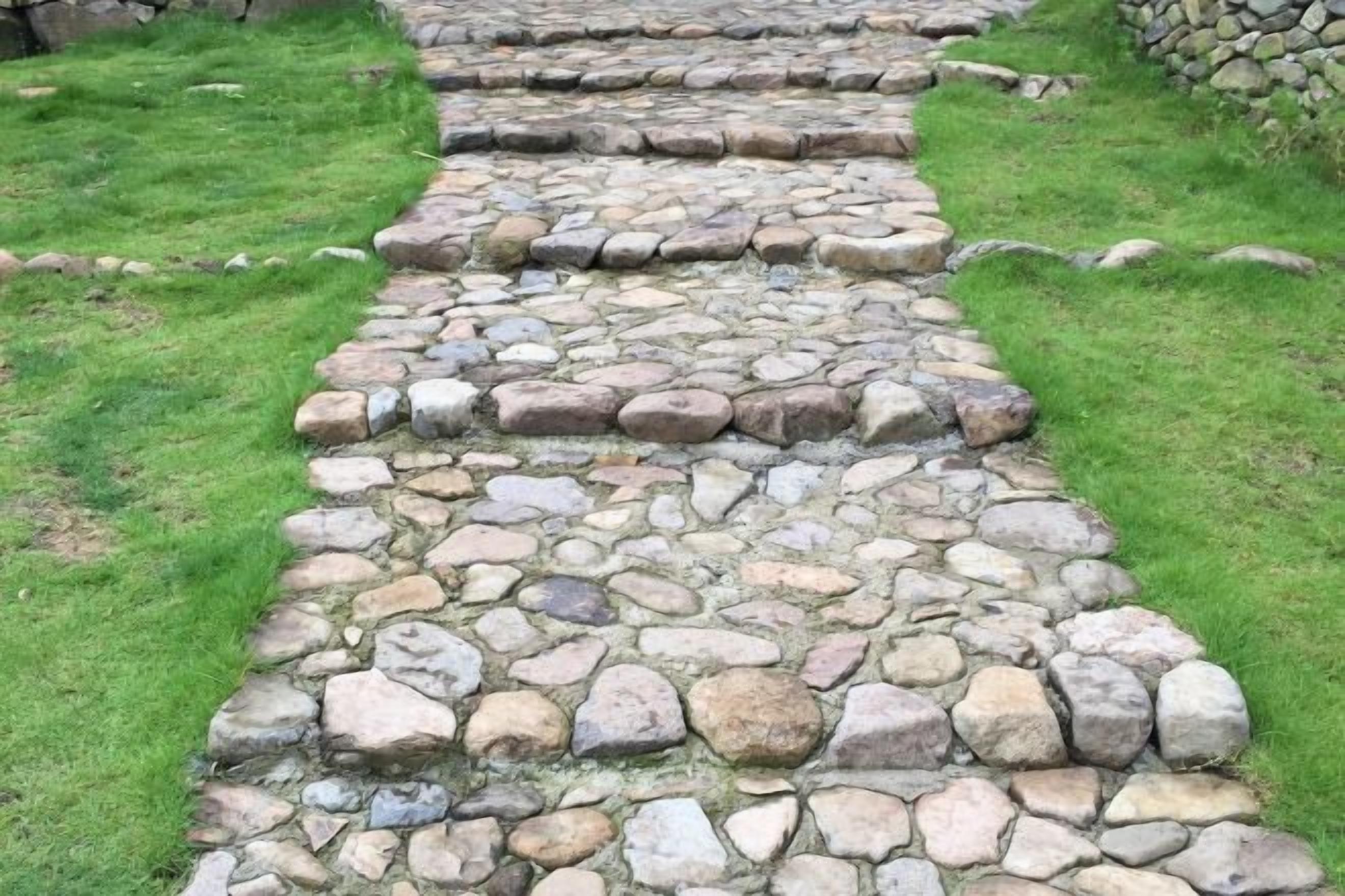 A stone pathway leading through a grassy area.