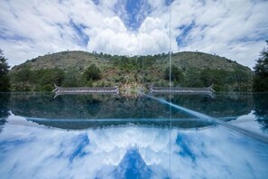 A tranquil lake with a traditional bridge and a hill in the background. - Sisigu View Inn (Lijiang)