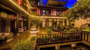 A traditional courtyard with wooden railings, potted plants, and a small water feature. - Sisigu View Inn (Lijiang)