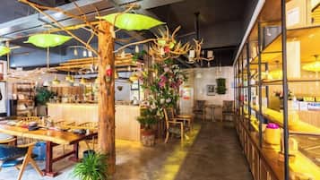 An interior with wooden furniture, a bar area, and decorative plants.