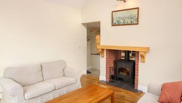 Una sala de estar con chimenea, dos sofás y una mesa de centro de madera.