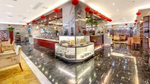 A modern hotel lobby with a marble floor, seating areas, and a central display with various items. - Xuanwei Meihuan Hotel (Xuanwei)
