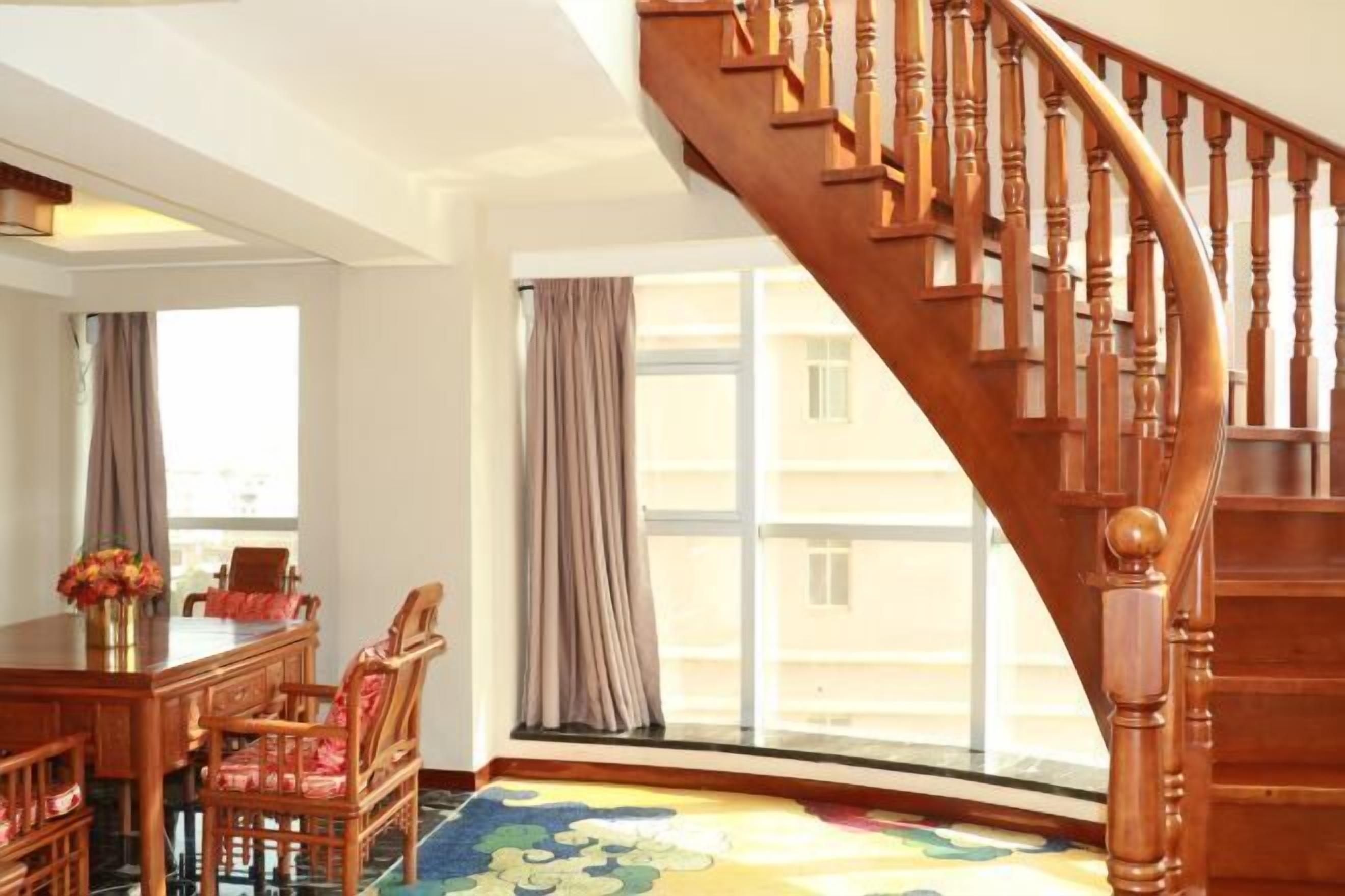 A wooden staircase with a curved design leading to an upper floor.