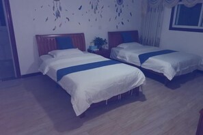 Habitación de hotel con dos camas, cabeceros de madera y un detalle decorativo en la pared.