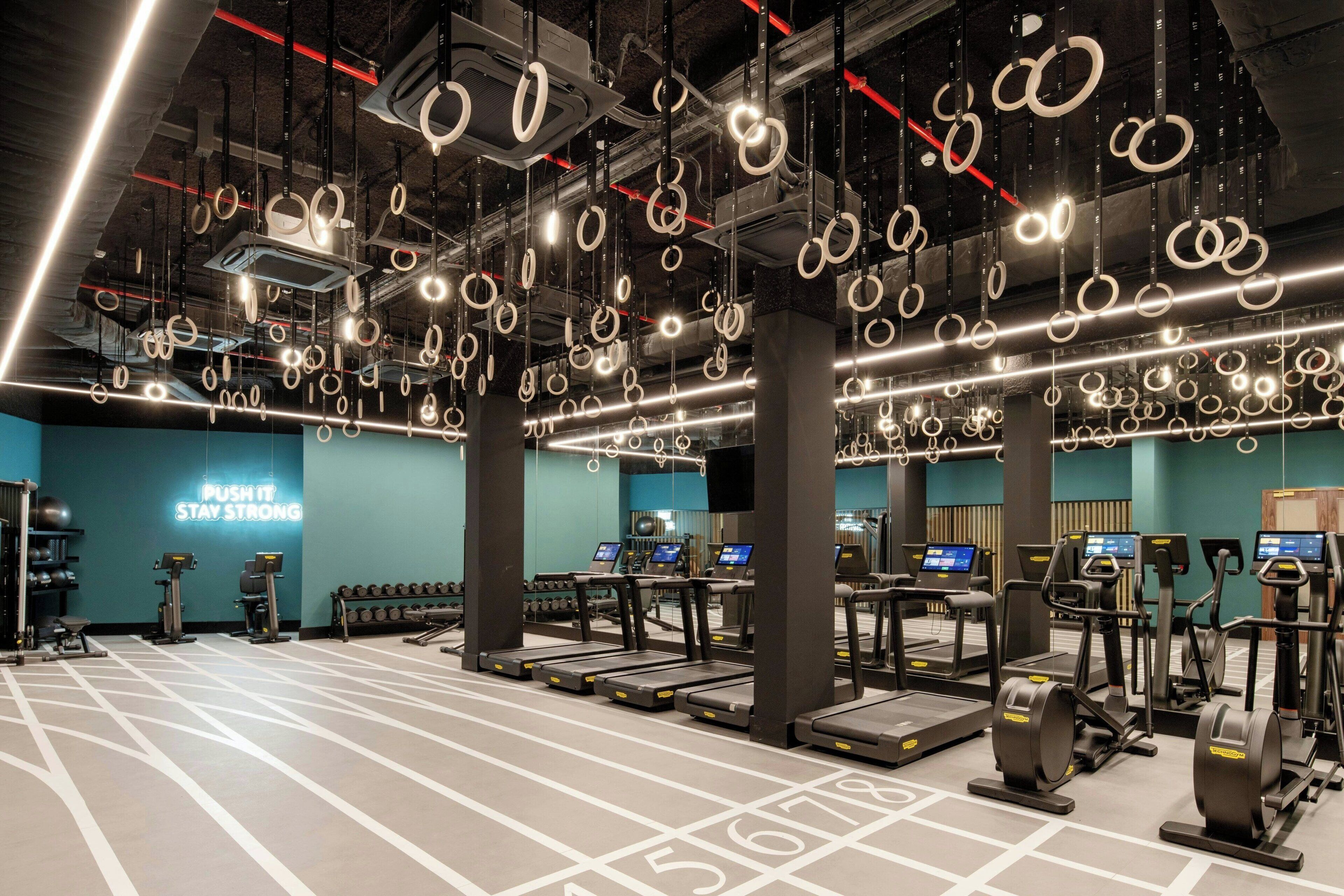Une salle de sport équipée de tapis de course, de vélos elliptiques et de poids libres.
