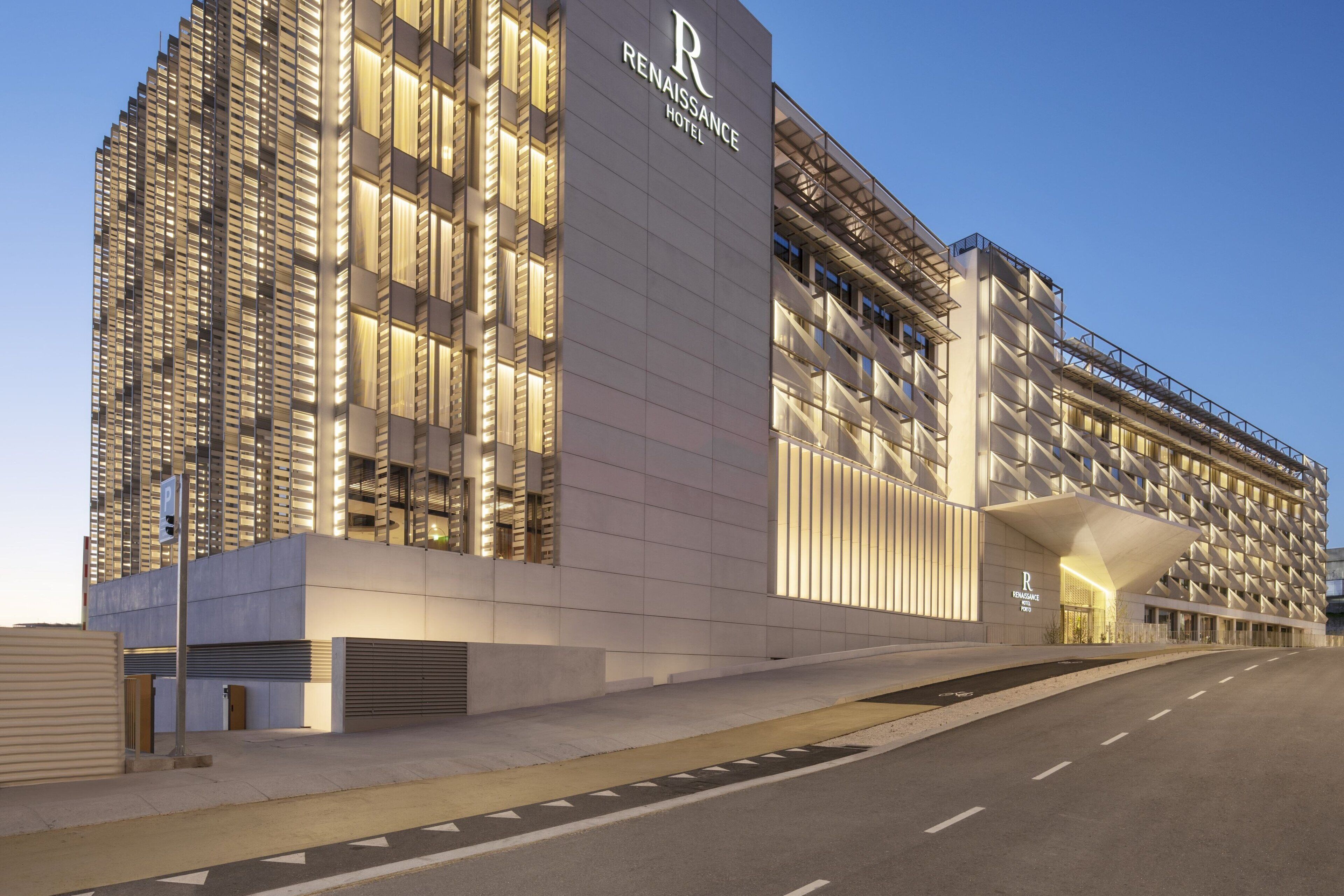 A modern hotel with a prominent 'Renaissance Hotel' sign, featuring a unique architectural design with a mix of glass and concrete elements.