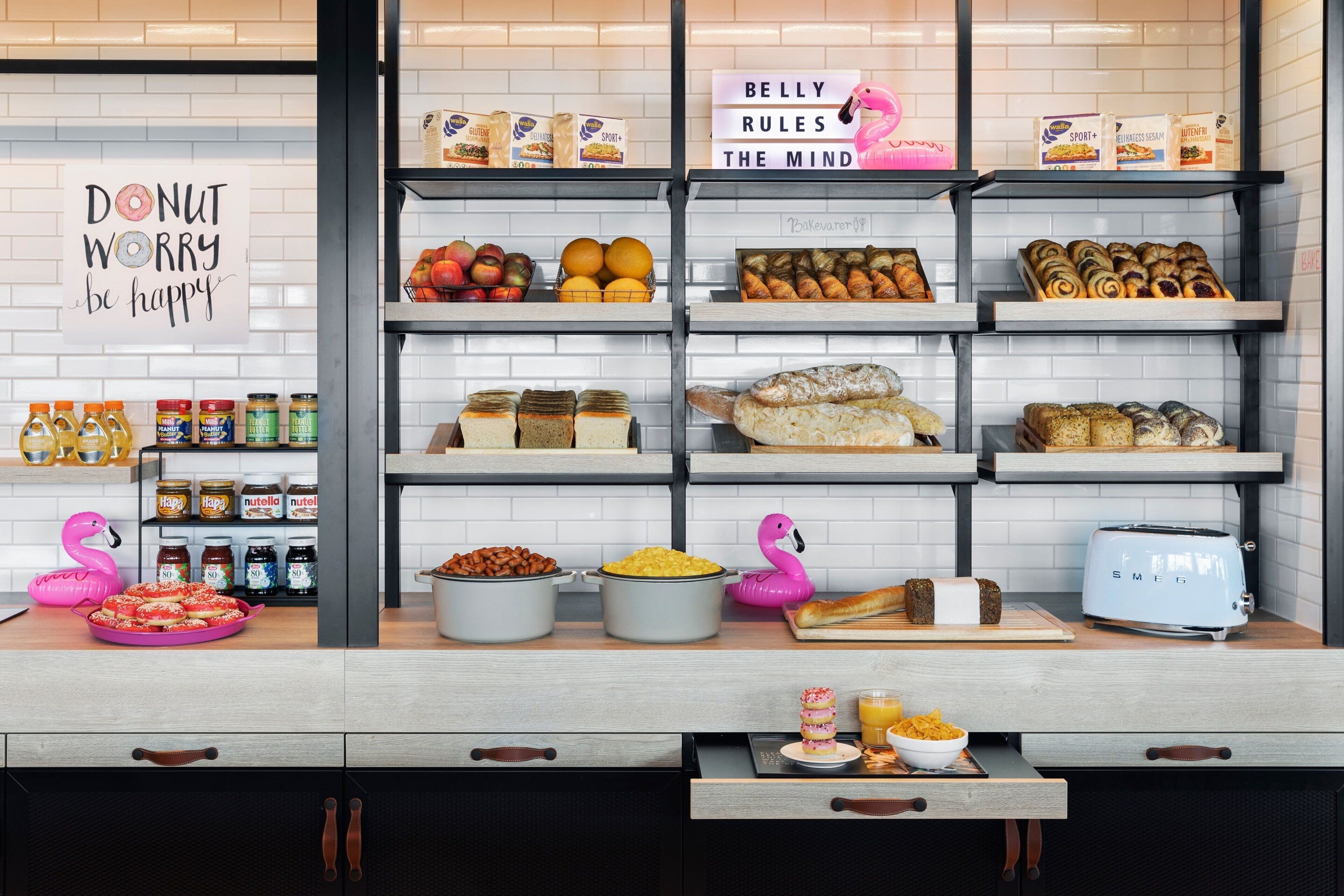 A bakery display with various baked goods, jars of spreads, and a toaster.