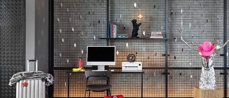 Una habitación moderna con escritorio, silla, computadora y adornos.