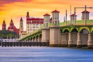 A bridge with green railings and a clock tower in the background. - Anastasia Adventure 2 (St. Augustine)
