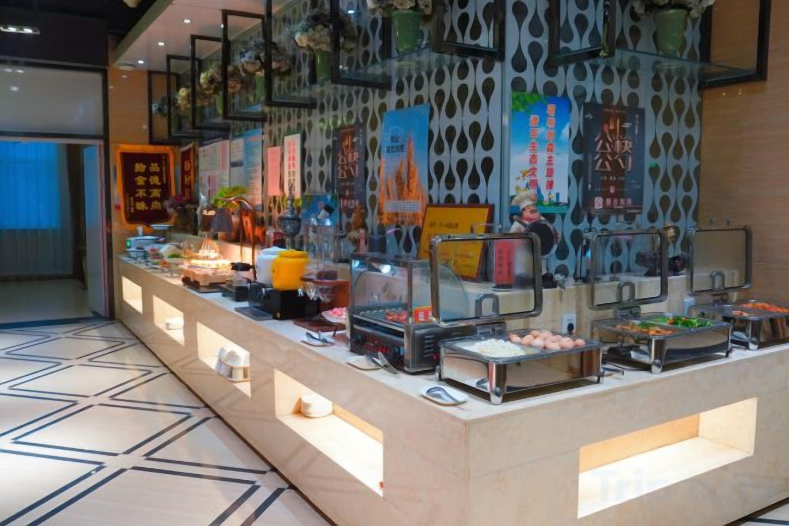 Disposição de buffet com diversos alimentos e uma parede decorativa com padrões.