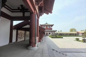 Un edificio tradicional con un camino empedrado y una pagoda al fondo.