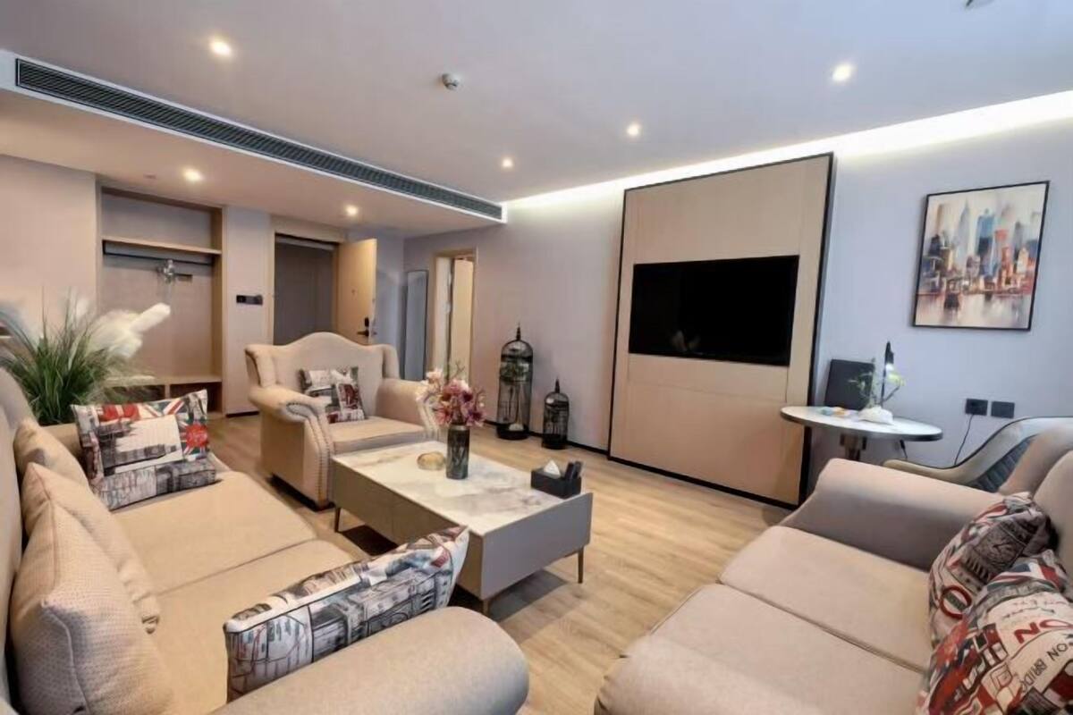 Una sala de estar moderna con un sofá, una mesa de centro y un televisor de pantalla plana montado en la pared.