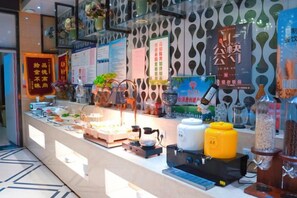A hotel reception area with a counter displaying various amenities, including a coffee machine, a kettle, and a selection of snacks. - Tianyi Mingdu Mansion (Longyao County)