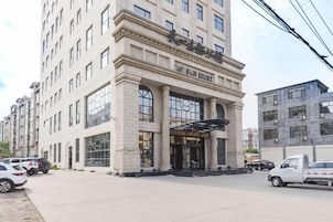 A multi-story hotel with a prominent entrance, large windows, and a modern architectural design.