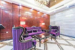 A lobby with a grand chandelier, plush purple sofas, and a marble floor. - Tianyi Mingdu Mansion (Longyao County)