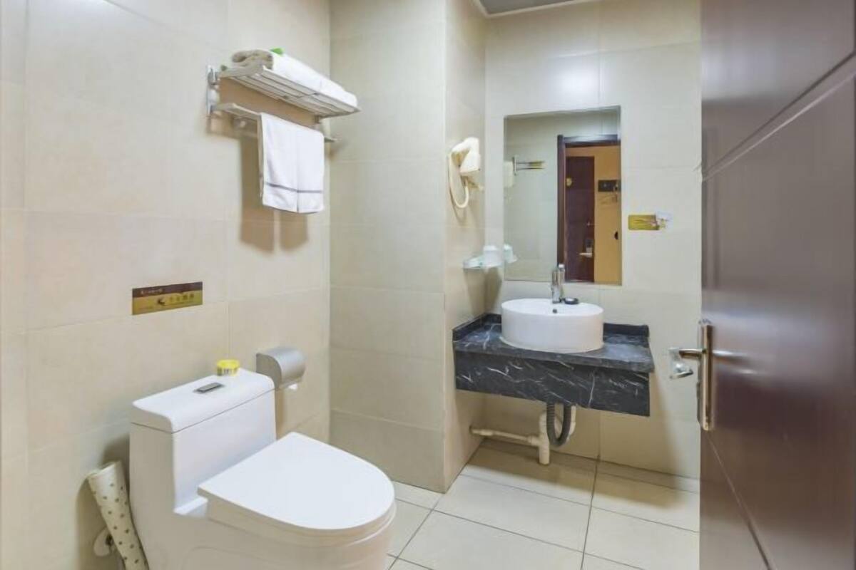 A bathroom with a toilet, sink, and mirror.