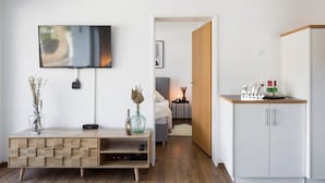 A modern living room with a flat-screen TV, wooden console, and a white cabinet. - Apartment Alpenglühen nahe Breitachklamm (Oberstdorf)