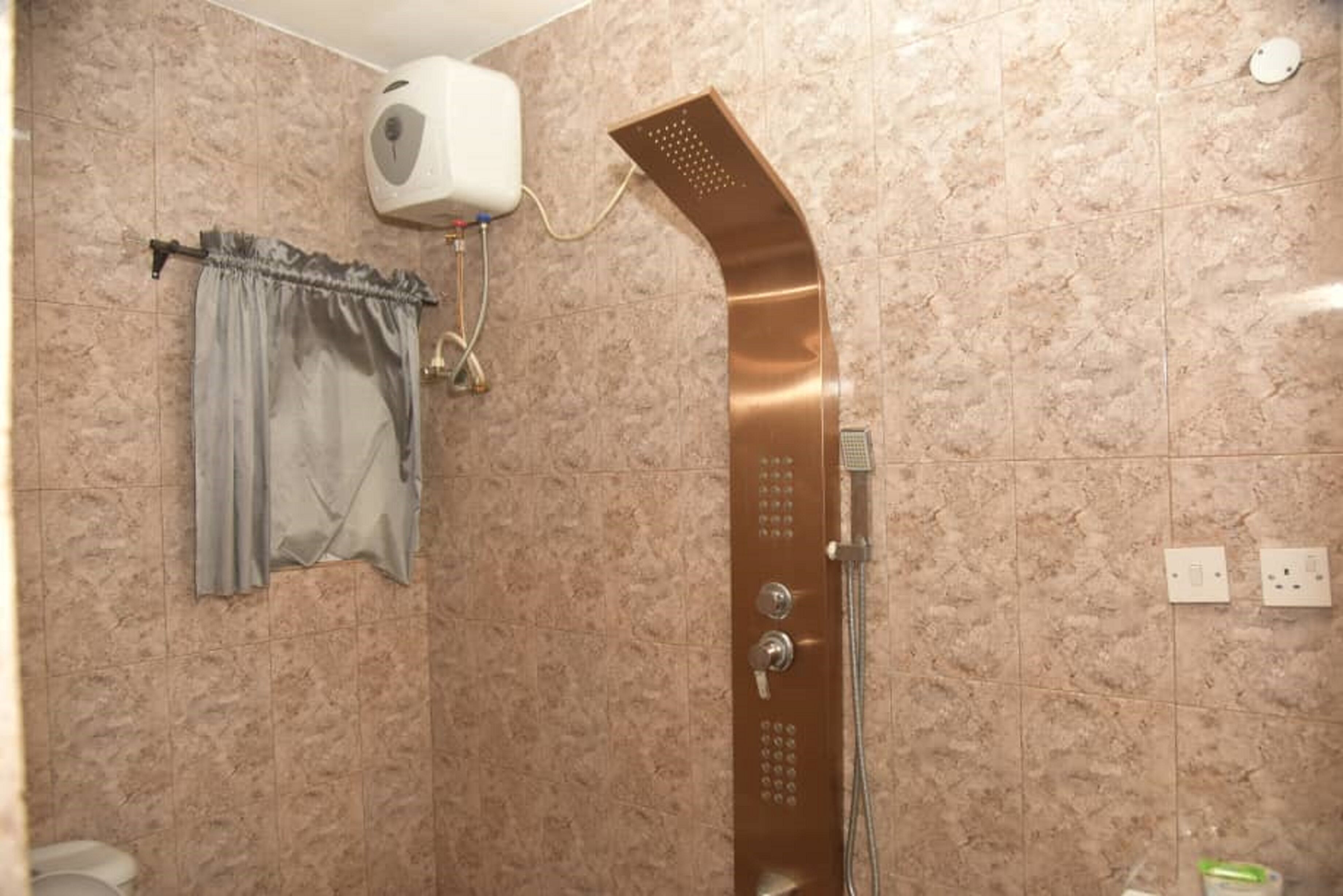 Une salle de bain avec une douche, un porte-serviettes et des toilettes.