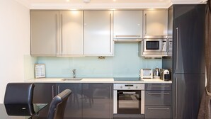 Una cocina moderna con electrodomésticos de acero inoxidable, lavavajillas y microondas.