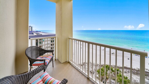 A balcony with wicker furniture and a view of the beach. - Grand Panama 809 Beachfront Escape, Beach Service + Pets OK! (Panama City Beach)