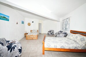 Ein Schlafzimmer mit zwei Holzbetten, einem Schlafsofa und einem kleinen Tisch.