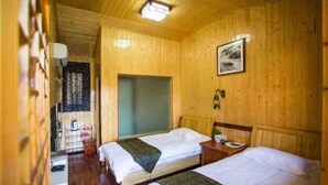 A wooden room with two beds, a window, and a door. - Youjian Nanshan Hotel (Xinchang)