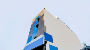 A modern building with a unique angular design, featuring a mix of blue and beige colors. - Victoria Palace (New Delhi)