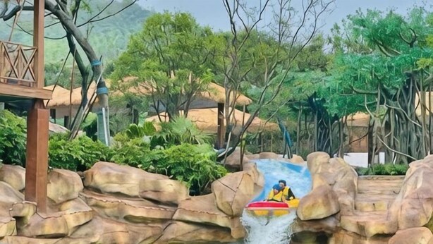A water ride with a raft, surrounded by rock formations and greenery. - Junda Hotel (Anji)