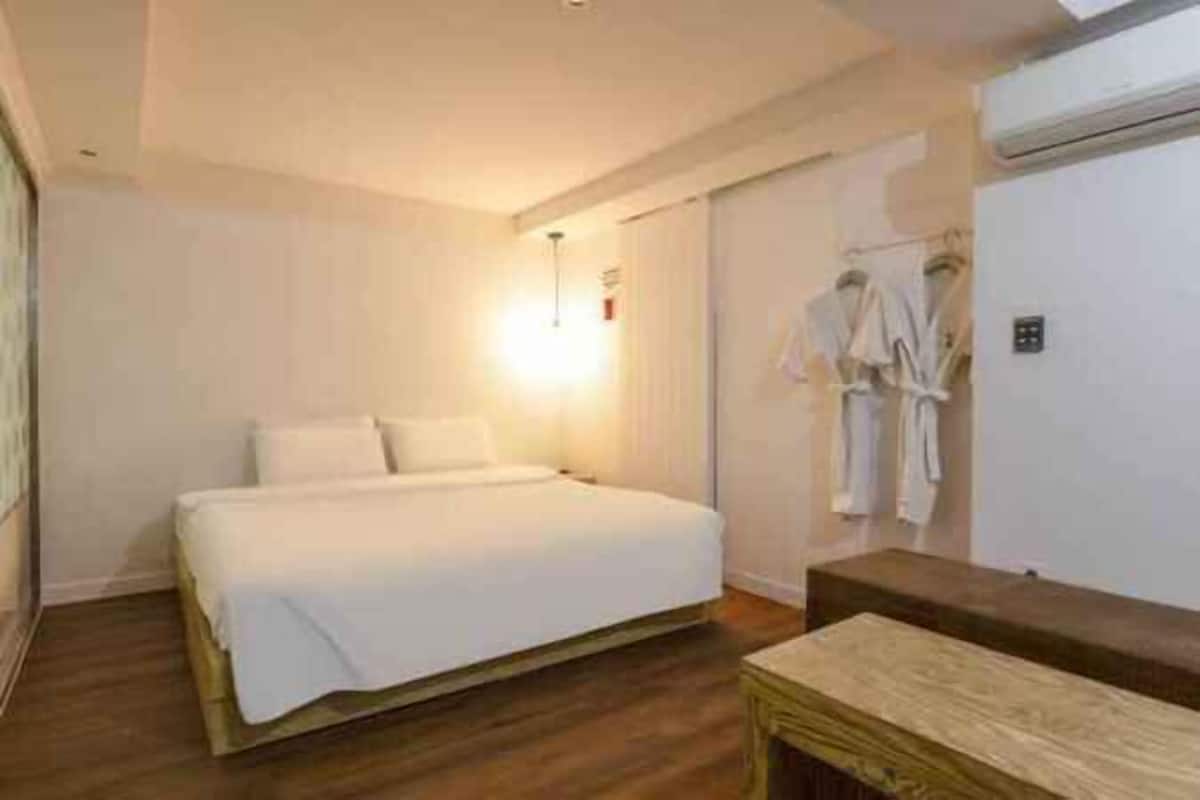 Una camera da letto con un letto, un comodino e un condizionatore d'aria a parete.