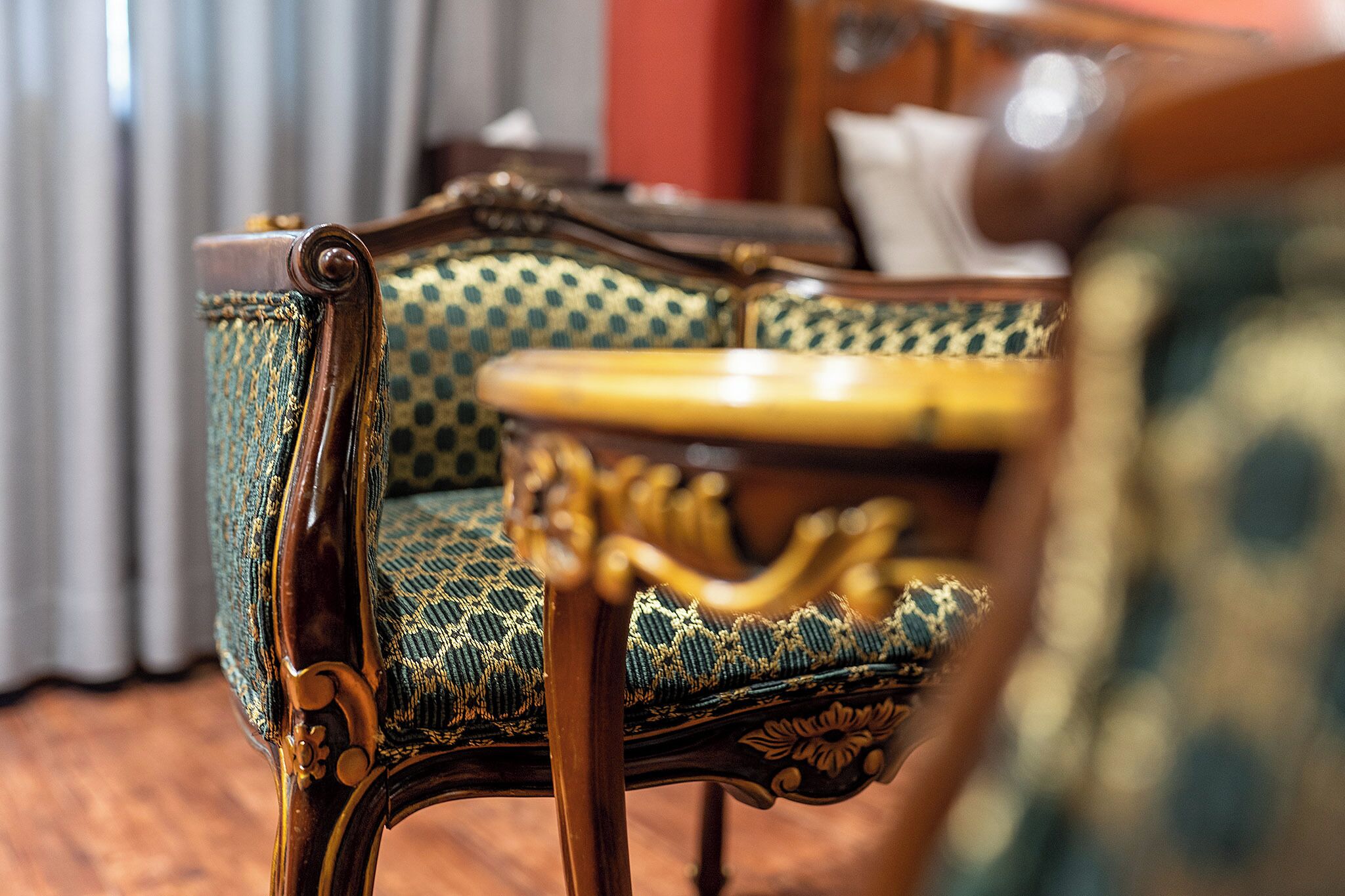 A vintage-style chair with intricate woodwork and a patterned fabric.