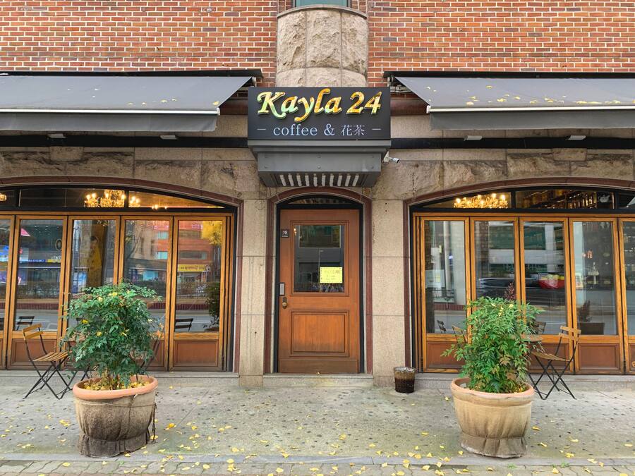 A storefront with a sign reading "Kayla 24 coffee & flower tea".