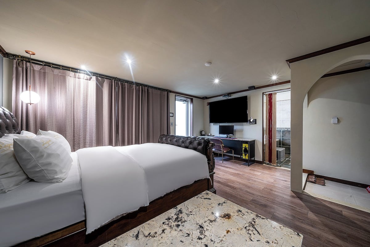 Una camera da letto con un letto grande, una scrivania e una televisione.