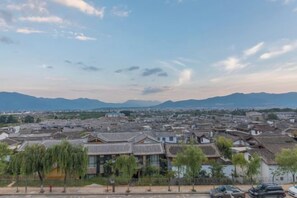 A traditional town with historical buildings and a view of distant mountains. - Lijiang cloud color · July time Inn (Lijiang)