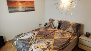 A bedroom with a bed, a painting, a wall light, and a wooden ceiling. - Gaspar House (Brenzone sul Garda)