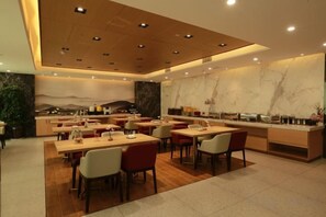 Un restaurante moderno con una barra larga y varias zonas de estar.