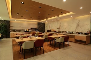 Un restaurante moderno con una barra larga y varias zonas de estar.