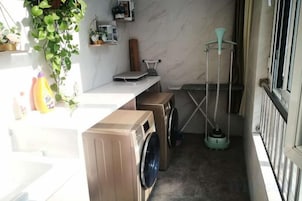 A laundry area with a washing machine, dryer, and a hanging rack.
