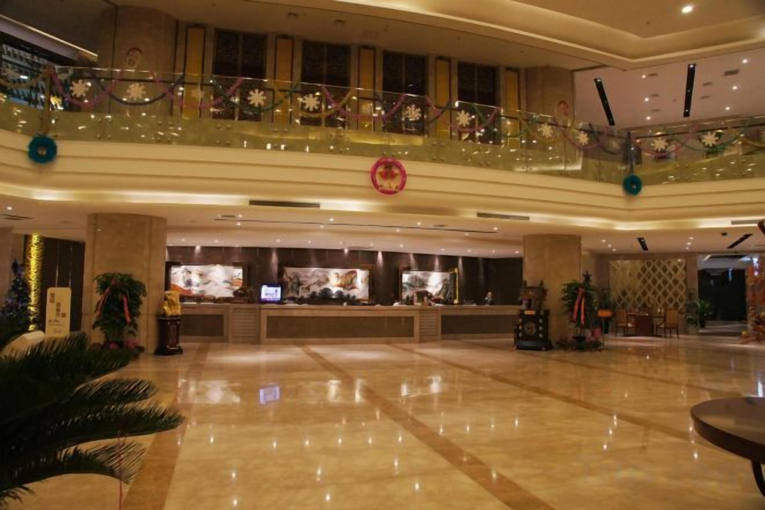 A spacious lobby with a reception desk, a glass balustrade, and a decorative circular emblem.