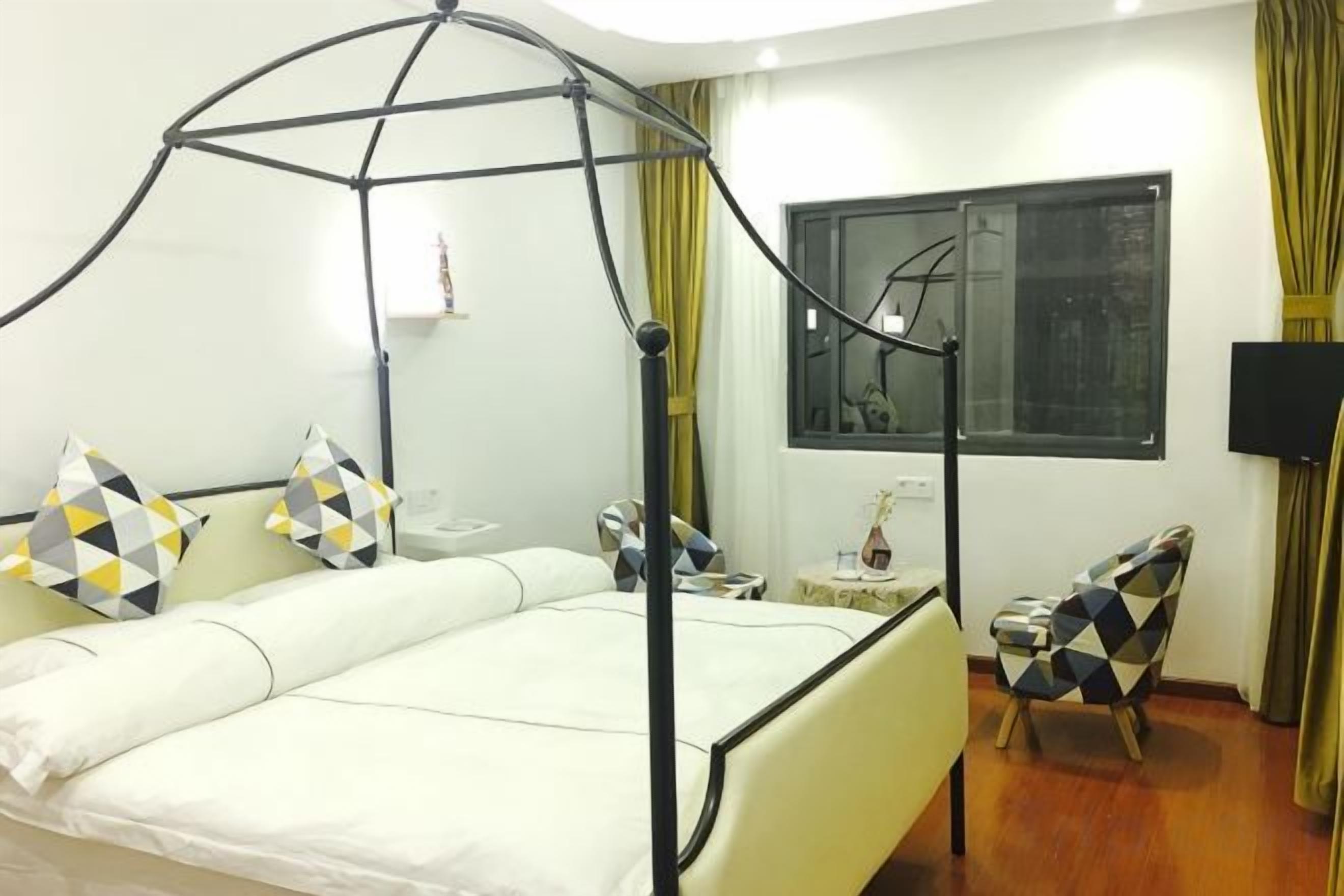 Une chambre d’hôtel avec un lit, une chaise, une fenêtre et un téléviseur.