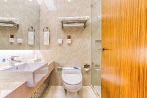 A modern bathroom with a sink, toilet, and towel racks. - Lianhuashan International Business Center (Changchun)
