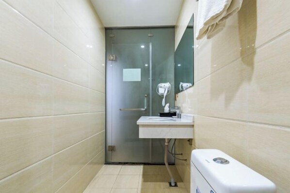 A small bathroom with a glass door, a white sink, and a hand dryer. - Tangmen Inn (Enshi)