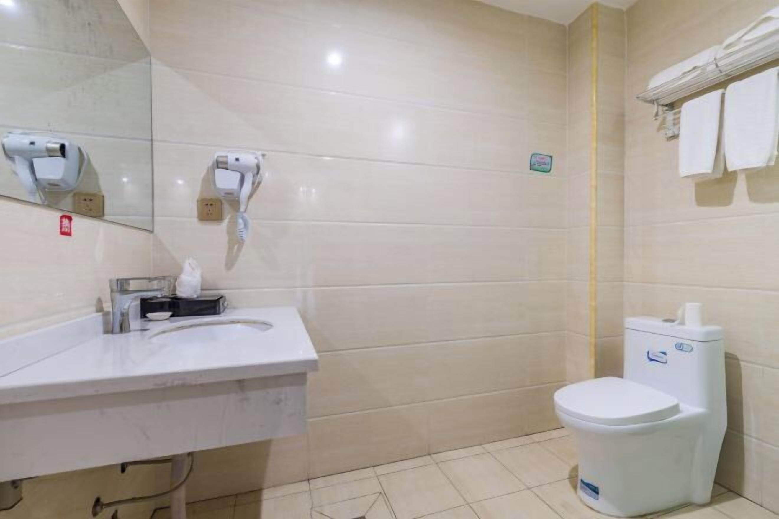 Un bany amb un lavabo blanc, un vàter i un mirall.