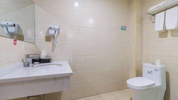 A bathroom with a white sink, a toilet, and a mirror.