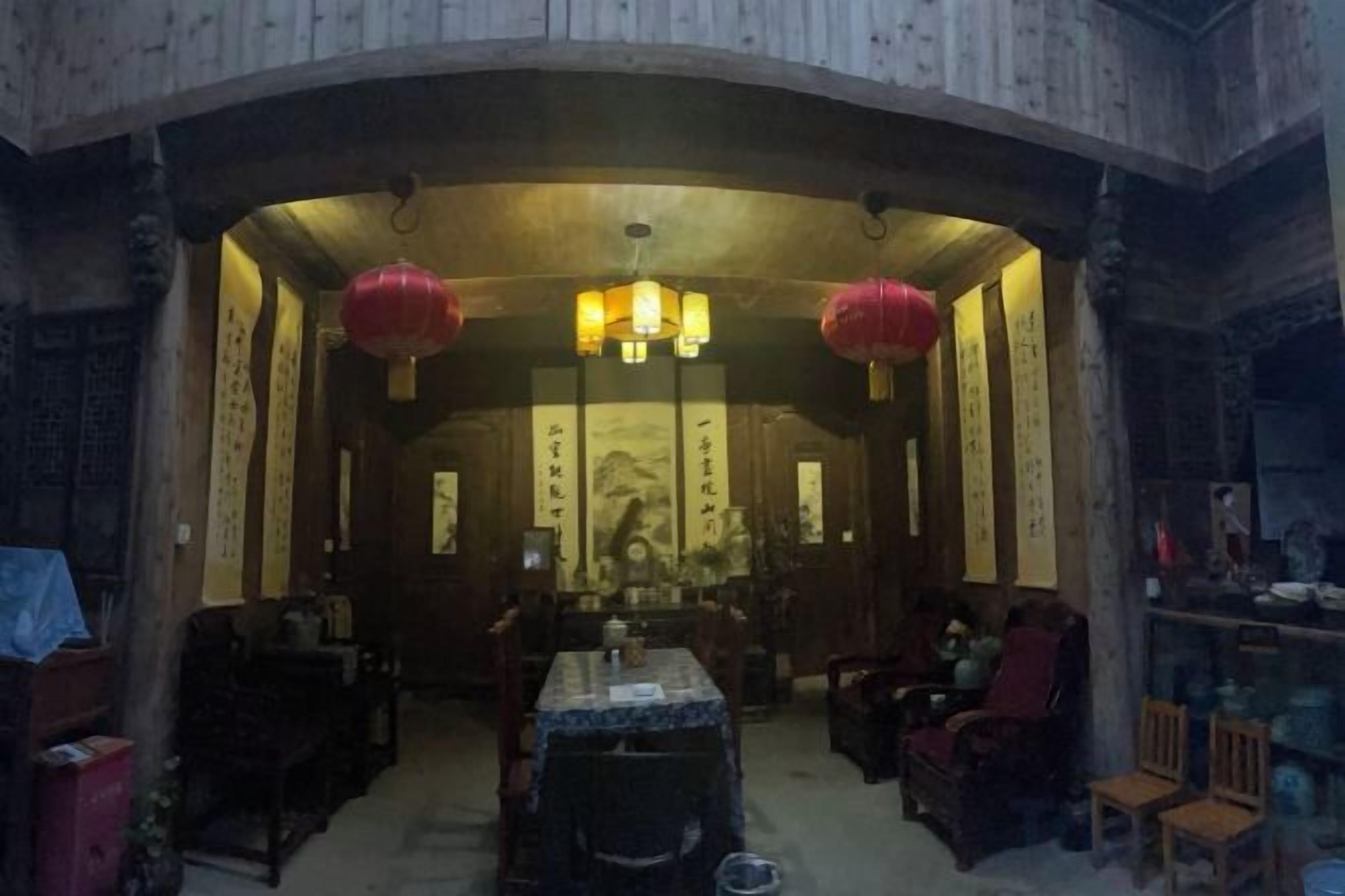 A traditional room with a curved wooden ceiling, a central table, and seating arrangements.