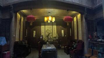 A traditional room with a curved wooden ceiling, a central table, and seating arrangements.