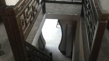 A staircase with a handrail and a metal gate at the top.