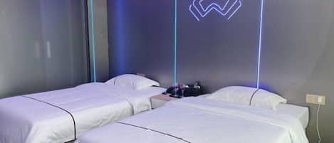 A hotel room with two beds, a Star Wars-themed neon light, and a window with blinds.