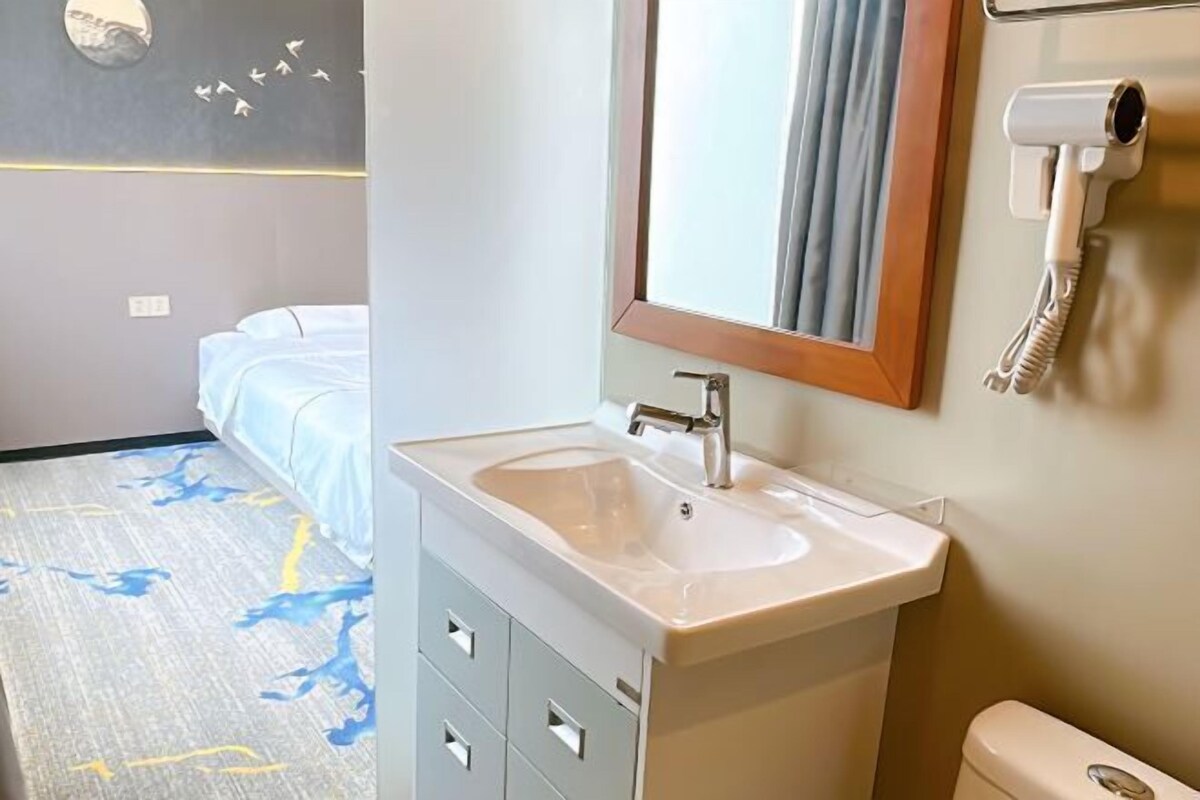 A bathroom with a sink, mirror, and hairdryer.